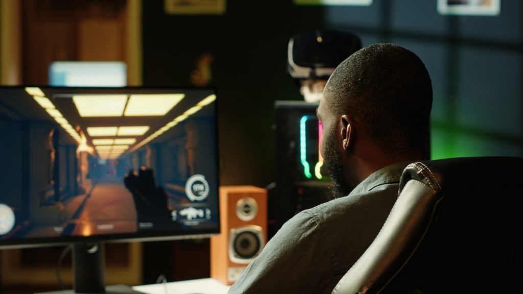 man sitting in front of his computer playing a video game