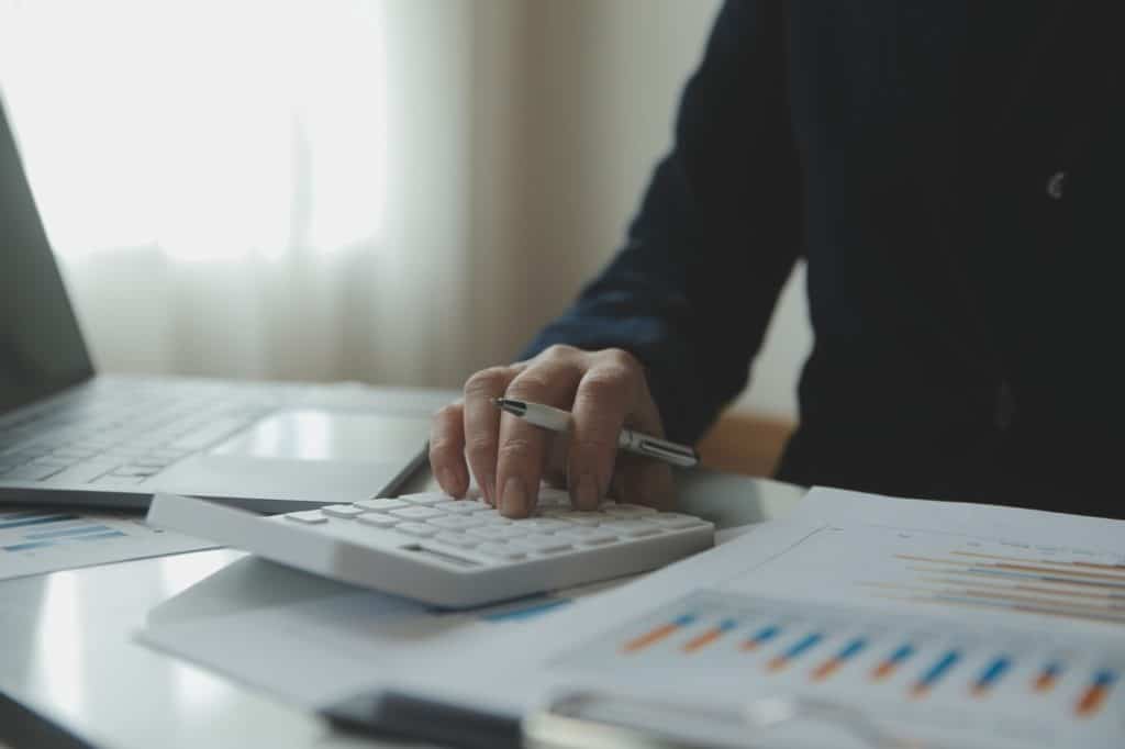 Woman using a calculator with a pen in her hand