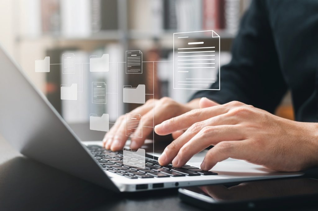 pair of hands working on a laptop
