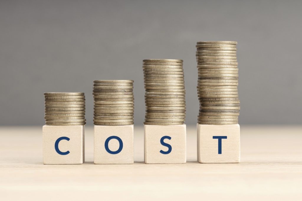 word cost spelled on small wooden blocks with coins tacked on top of each