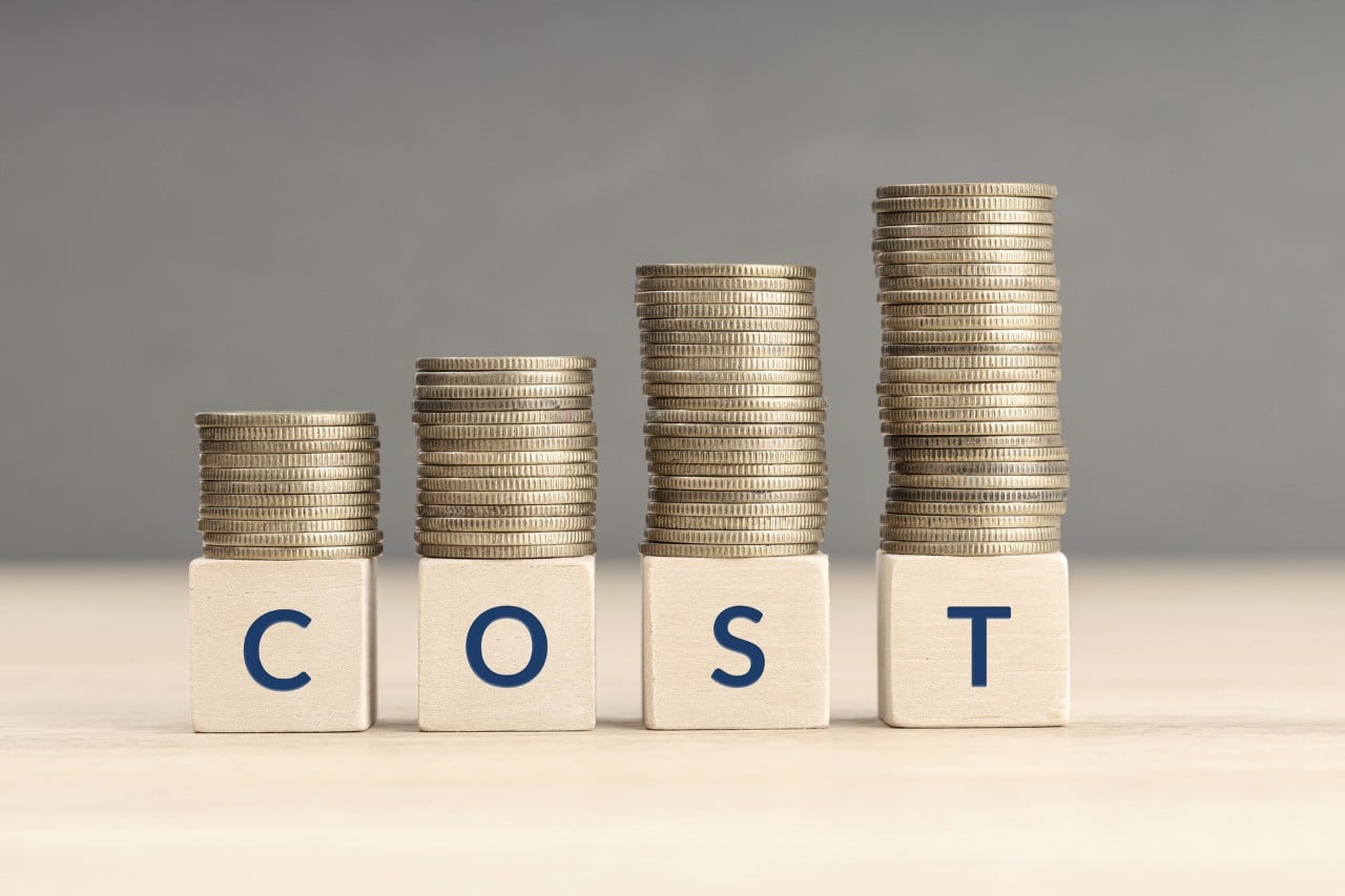 word cost spelled on small wooden blocks with coins tacked on top of each